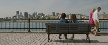 Movie still from “Mr. Nobody” (2009), directed by Jaco Van Dormael – Two people sitting on a bench looking out at a city; Wide shot, Over the shoulder angle