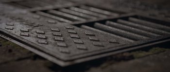 Movie still from “Mr. Nobody” (2009), directed by Jaco Van Dormael – View of a metal grate on the ground; Extreme Close Up shot, Overhead angle