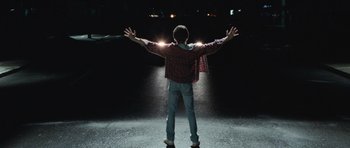 Movie still from “Mr. Nobody” (2009), directed by Jaco Van Dormael – A man standing in the middle of a street with his arms outstretched; Medium shot, Low angle