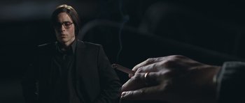 Movie still from “Mr. Nobody” (2009), directed by Jaco Van Dormael – A man in a suit smoking a cigarette in front of another man; Close Up shot, Over the shoulder angle