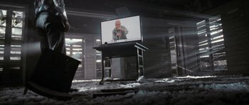Movie still from “Mr. Nobody” (2009), directed by Jaco Van Dormael – A man sitting in front of a television on a table; Wide shot, Low angle
