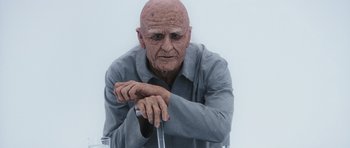 Movie still from “Mr. Nobody” (2009), directed by Jaco Van Dormael – An old man sitting on top of a metal chair; Close Up shot, Low angle