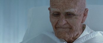 Movie still from “Mr. Nobody” (2009), directed by Jaco Van Dormael – An old man sitting in a hospital bed looking sad; Close Up shot, Low angle