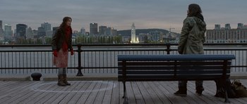 Movie still from “Mr. Nobody” (2009), directed by Jaco Van Dormael – A person sitting on top of a bench near a body of water; Extreme Wide shot, Over the shoulder angle