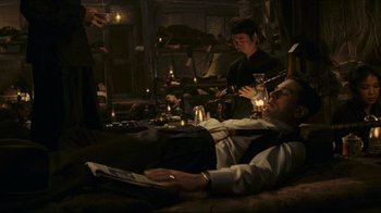 Movie still from “Once Upon a Time in America” (1984), directed by Sergio Leone – A man laying on the ground reading a newspaper; Medium shot, High angle