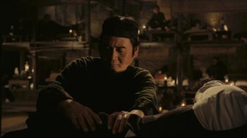 Movie still from “Once Upon a Time in America” (1984), directed by Sergio Leone – A man sitting in front of a table with candles; Medium shot, Low angle