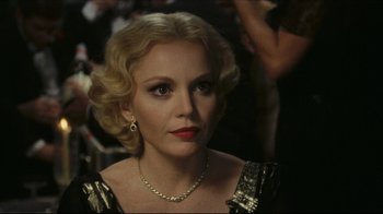 Movie still from “Once Upon a Time in America” (1984), directed by Sergio Leone – A woman with blonde curly hair wearing a gold dress; Close Up shot, Over the shoulder angle