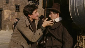 Movie still from “Once Upon a Time in America” (1984), directed by Sergio Leone – Two men in suits and hats one of which has his hand on the other's collar; Medium shot, Over the shoulder angle