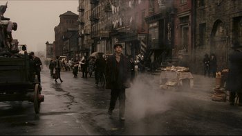 Movie still from “Once Upon a Time in America” (1984), directed by Sergio Leone – A man is walking down the street in the rain; Wide shot, High angle