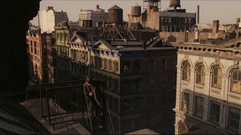 Movie still from “Once Upon a Time in America” (1984), directed by Sergio Leone – A man standing on top of a fire hydrant on top of a building; Extreme Wide shot, Overhead angle