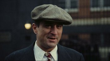Movie still from “Once Upon a Time in America” (1984), directed by Sergio Leone – A person wearing a suit and a hat; Close Up shot, Over the shoulder angle