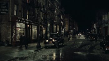 Movie still from “Once Upon a Time in America” (1984), directed by Sergio Leone – An old car is driving down the street at night; Extreme Wide shot, High angle