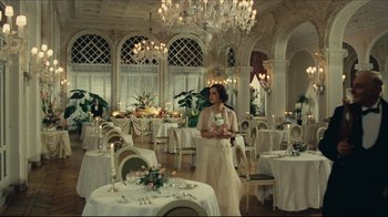 Movie still from “Once Upon a Time in America” (1984), directed by Sergio Leone – A woman in a white dress in a dining room; Wide shot, Low angle
