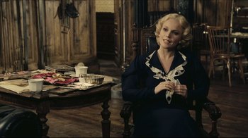 Movie still from “Once Upon a Time in America” (1984), directed by Sergio Leone – A woman sitting in front of a wooden table; Medium shot, Over the shoulder angle