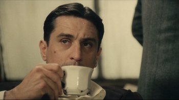 Movie still from “Once Upon a Time in America” (1984), directed by Sergio Leone – A person drinking a cup of coffee; Close Up shot, Low angle
