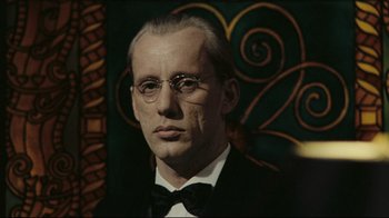 Movie still from “Once Upon a Time in America” (1984), directed by Sergio Leone – A person wearing a suit and glasses; Close Up shot, Low angle