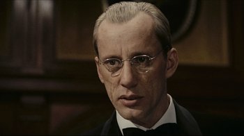 Movie still from “Once Upon a Time in America” (1984), directed by Sergio Leone – A person wearing a suit and glasses; Close Up shot, Low angle