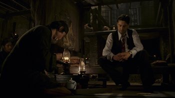 Movie still from “Once Upon a Time in America” (1984), directed by Sergio Leone – Two men sitting in a dimly - lit living room; Medium shot, High angle