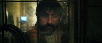 Movie still from “Once Upon a Time in Anatolia” (2011), directed by Nuri Bilge Ceylan – A man with a beard looking through a window; Close Up shot, Low angle