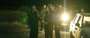 Movie still from “Once Upon a Time in Anatolia” (2011), directed by Nuri Bilge Ceylan – A man in black jacket shaking hands next to a man in black jacket; Medium shot, Over the shoulder angle
