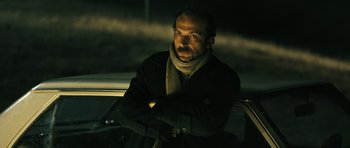 Movie still from “Once Upon a Time in Anatolia” (2011), directed by Nuri Bilge Ceylan – A man sitting in the back seat of a car at night; Close Up shot, Low angle