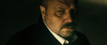 Movie still from “Once Upon a Time in Anatolia” (2011), directed by Nuri Bilge Ceylan – A person wearing a suit and tie; Close Up shot, Low angle