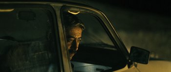 Movie still from “Once Upon a Time in Anatolia” (2011), directed by Nuri Bilge Ceylan – A man sitting in the driver's seat of a car; Close Up shot, Low angle