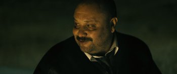 Movie still from “Once Upon a Time in Anatolia” (2011), directed by Nuri Bilge Ceylan – A person wearing a suit and tie; Close Up shot, Low angle