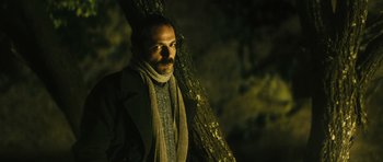 Movie still from “Once Upon a Time in Anatolia” (2011), directed by Nuri Bilge Ceylan – A man standing next to a tree in the dark; Close Up shot, Low angle