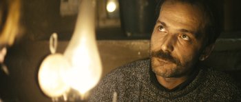 Movie still from “Once Upon a Time in Anatolia” (2011), directed by Nuri Bilge Ceylan – A person looking at a light bulb; Close Up shot, Low angle