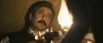 Movie still from “Once Upon a Time in Anatolia” (2011), directed by Nuri Bilge Ceylan – A man with a mustache looking at a candle; Close Up shot, Low angle
