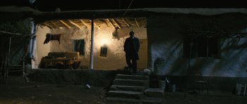 Movie still from “Once Upon a Time in Anatolia” (2011), directed by Nuri Bilge Ceylan – A man standing on steps in front of a building; Wide shot, Low angle
