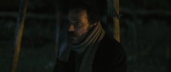 Movie still from “Once Upon a Time in Anatolia” (2011), directed by Nuri Bilge Ceylan – A man wearing a scarf and a jacket in the dark; Close Up shot, Low angle