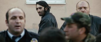 Movie still from “Once Upon a Time in Anatolia” (2011), directed by Nuri Bilge Ceylan – A man with long hair and a black leather jacket; Close Up shot, Over the shoulder angle