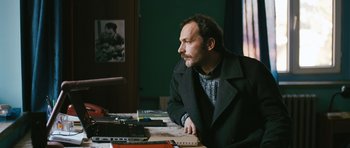 Movie still from “Once Upon a Time in Anatolia” (2011), directed by Nuri Bilge Ceylan – A man sitting at a table looking off into the distance; Medium shot, High angle