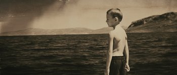 Movie still from “Once Upon a Time in Anatolia” (2011), directed by Nuri Bilge Ceylan – A young boy standing in front of a body of water; Medium shot, Overhead angle