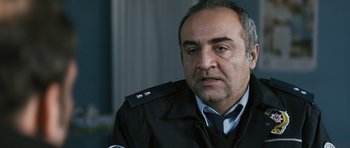 Movie still from “Once Upon a Time in Anatolia” (2011), directed by Nuri Bilge Ceylan – A man in a police uniform looks at the camera; Close Up shot, Over the shoulder angle