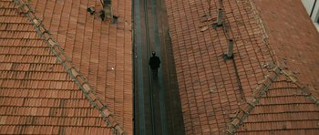 Movie still from “Once Upon a Time in Anatolia” (2011), directed by Nuri Bilge Ceylan – A person is walking on a train track on the roof of a building; Extreme Wide shot, Overhead angle