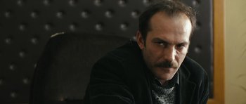 Movie still from “Once Upon a Time in Anatolia” (2011), directed by Nuri Bilge Ceylan – A person with a mustache wearing a jacket; Close Up shot, Low angle