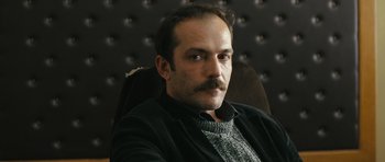 Movie still from “Once Upon a Time in Anatolia” (2011), directed by Nuri Bilge Ceylan – A person sitting in a chair; Close Up shot, Low angle