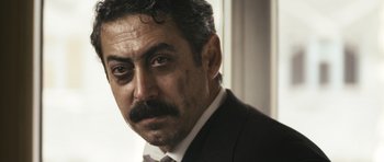 Movie still from “Once Upon a Time in Anatolia” (2011), directed by Nuri Bilge Ceylan – A person wearing a suit and tie; Close Up shot, Low angle
