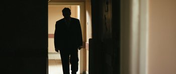 Movie still from “Once Upon a Time in Anatolia” (2011), directed by Nuri Bilge Ceylan – A man in a suit walking down a hall way; Wide shot, Low angle