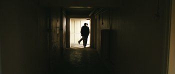 Movie still from “Once Upon a Time in Anatolia” (2011), directed by Nuri Bilge Ceylan – A man walking down a hall way with an umbrella; Wide shot, Low angle