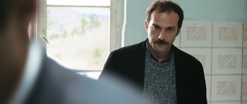 Movie still from “Once Upon a Time in Anatolia” (2011), directed by Nuri Bilge Ceylan – A person wearing a jacket; Close Up shot, Over the shoulder angle