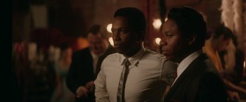 Movie still from “One Night in Miami...” (2020), directed by Regina King – A man wearing a white shirt and a tie; Medium shot, Over the shoulder angle