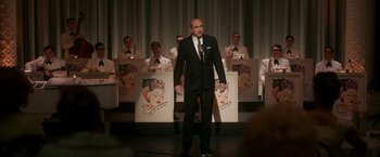 Movie still from “One Night in Miami...” (2020), directed by Regina King – A man standing on a stage in front of a microphone; Medium shot, Over the shoulder angle