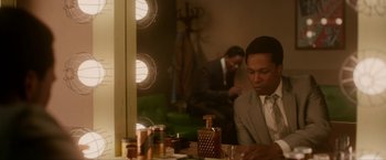 Movie still from “One Night in Miami...” (2020), directed by Regina King – A man sitting in front of a mirror in a room; Medium shot, Over the shoulder angle