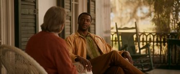 Movie still from “One Night in Miami...” (2020), directed by Regina King – A man sitting on a chair talking to a woman; Medium shot, Over the shoulder angle
