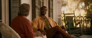 Movie still from “One Night in Miami...” (2020), directed by Regina King – A man sitting on a chair next to a woman; Medium shot, Over the shoulder angle