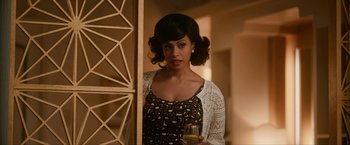 Movie still from “One Night in Miami...” (2020), directed by Regina King – A woman holding a glass of wine standing in front of a door; Close Up shot, Over the shoulder angle